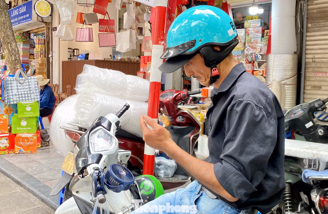 Một số người lao động sử dụng quạt điện mini được gắn ở tay cầm, hoặc dưới thanh sắt để đồ trên xe máy...