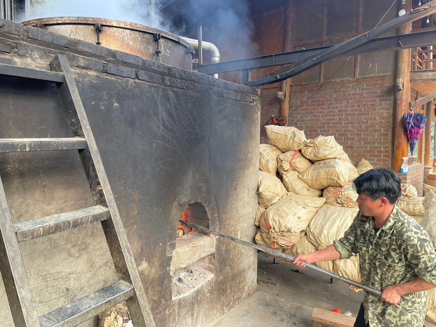 Nhân viên Hợp tác xã Cộng đồng Dao đỏ nhóm lửa đun nước tắm lá thuốc.