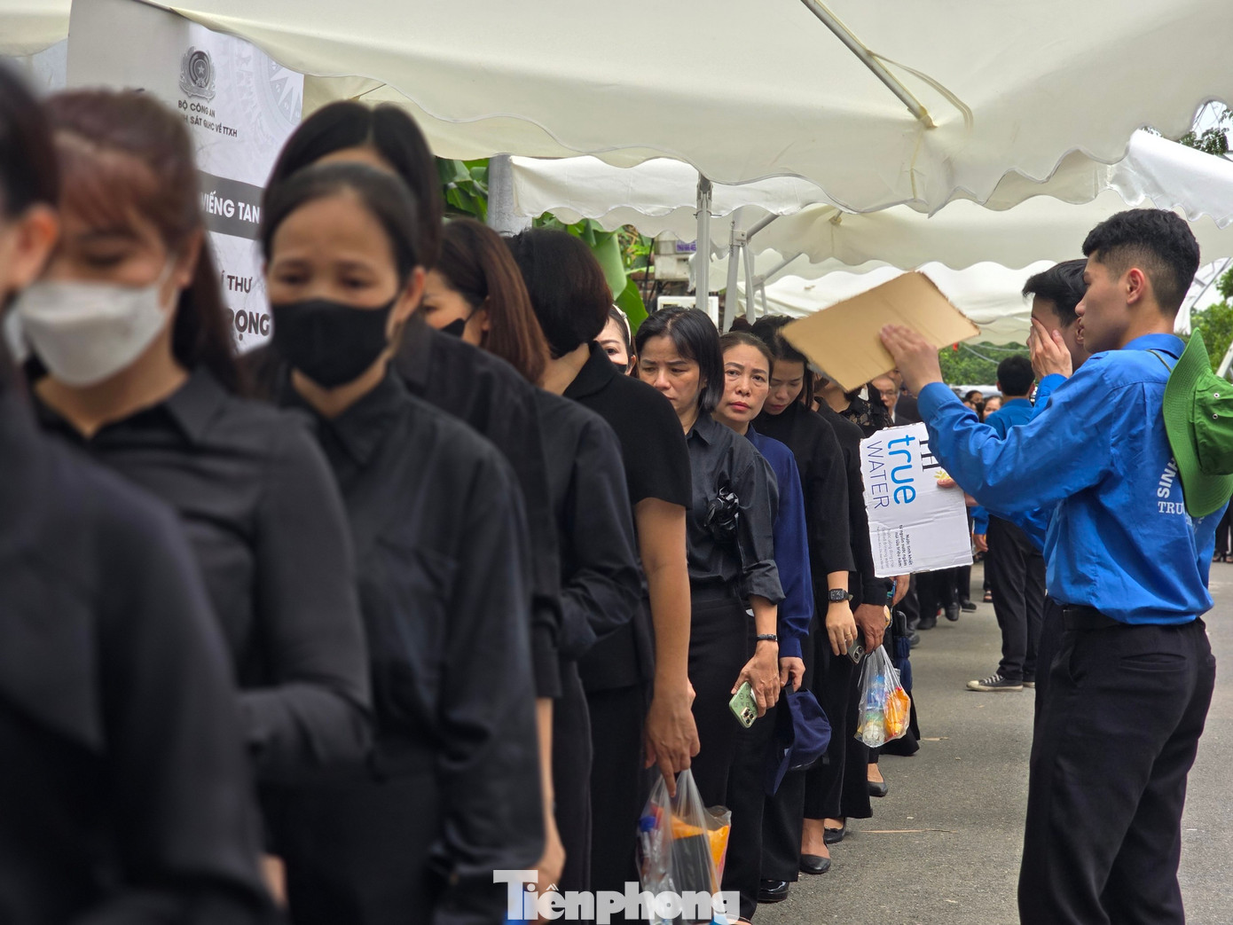 Các cơ quan, đoàn thể được hỗ trợ để phân luồng giao thông, tiếp nước và quạt mát cho người dân đến viếng Tổng Bí thư. Trong ảnh, các đoàn viên xã Đông Hội hỗ trợ quạt mát cho người dân.