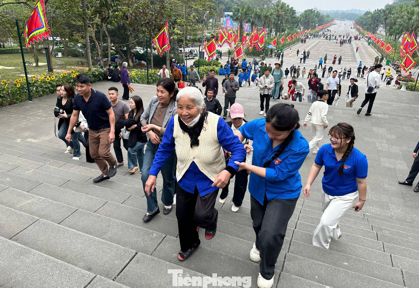 Thanh niên hỗ trợ người già leo lên các bậc thang.