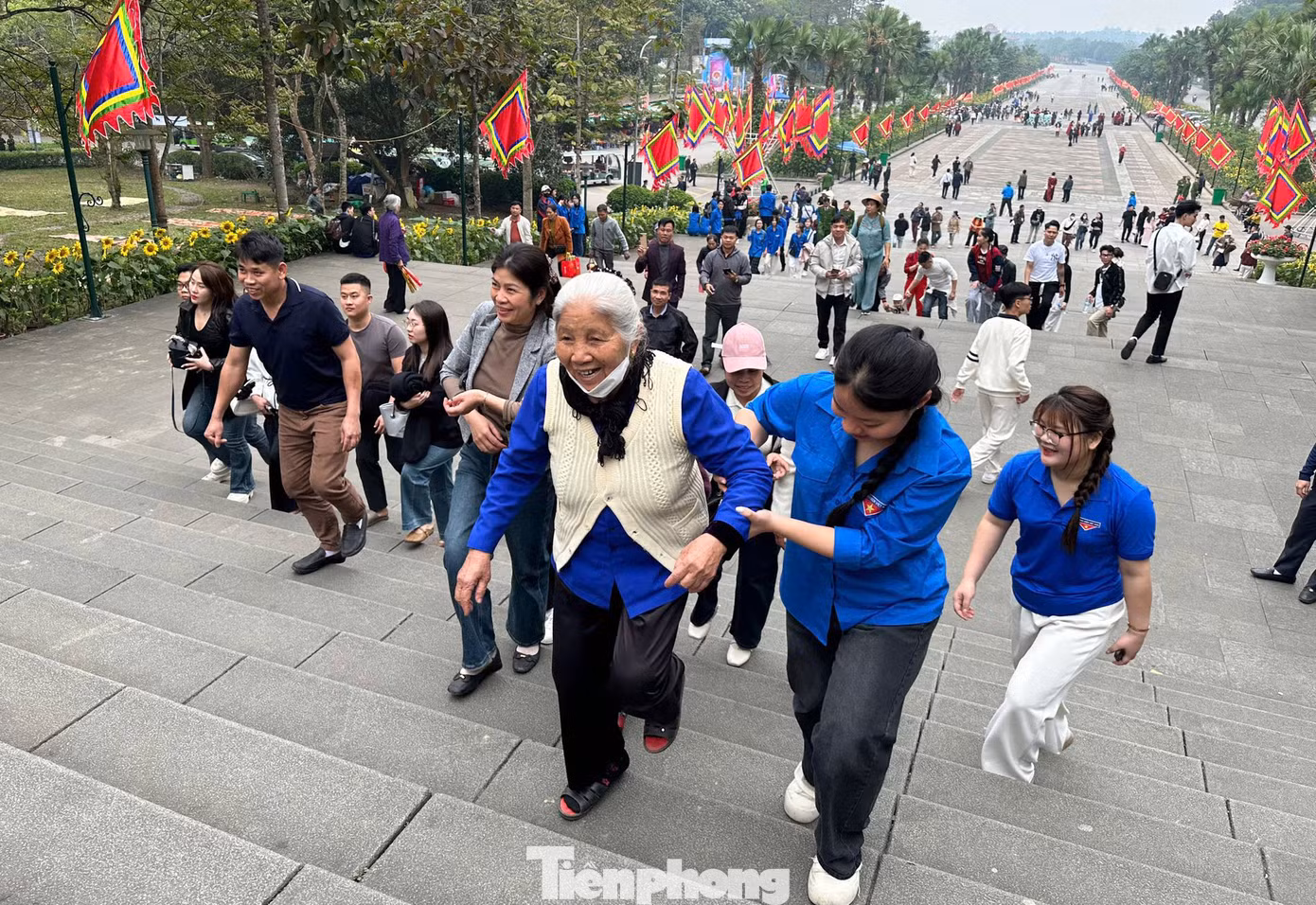 Thanh niên hỗ trợ người già leo lên các bậc thang.