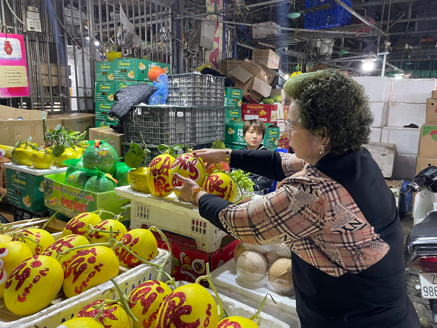 Tại chợ đầu mối hoa quả Long Biên, Hà Nội, hoa quả tạo hình độc lạ bắt đầu được bày bán từ ngày 23 tháng chạp âm lịch đến sát Tết. Trong ảnh, dưa Kim cô nương thư pháp có giá 130.000 đồng/ quả, bưởi Diễn thỏi vàng tài lộc có giá 200.000 đồng/quả được bày bán.