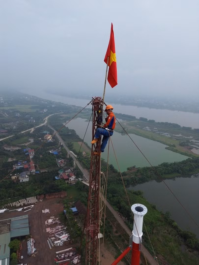 Theo những kỹ sư thi công tại đây, độ cao cột thép đã vượt quá giới hạn mà cần cẩu thông thường có thể vươn tới. Vì thế, họ sử dụng cần bích để đưa các thanh thép dài nặng từ 3- 5 tấn lên cao. Trên đỉnh cần bích luôn có lá cờ tổ quốc tung bay trong gió.