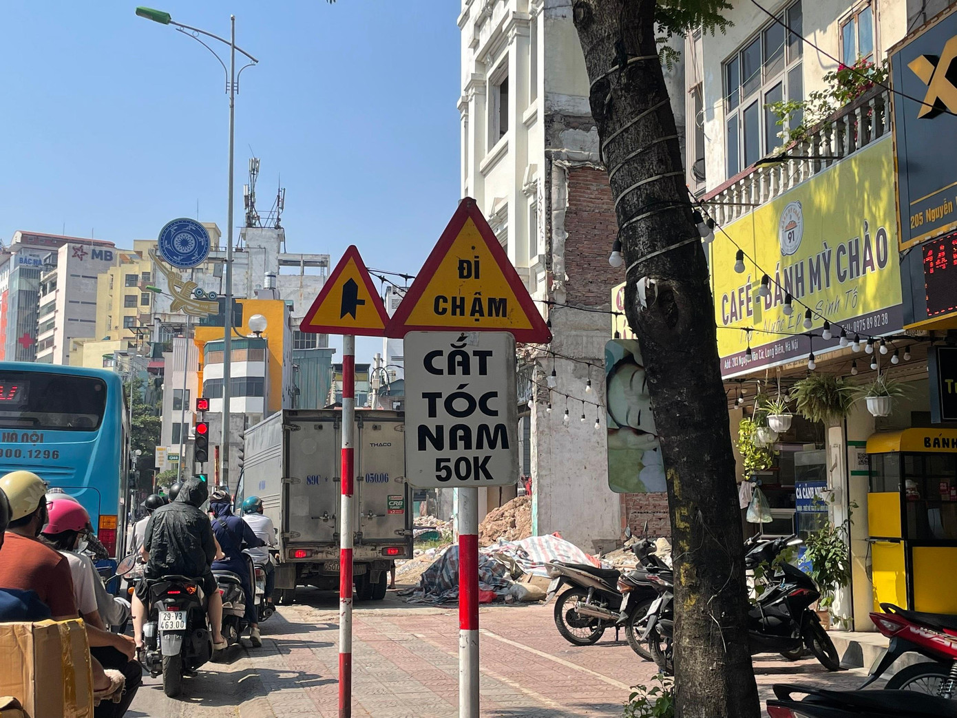 Một biển báo giao thông cũng bị các biển quảng cáo nhỏ lẻ bị gắn vào (ảnh chụp trên đường Nguyễn Văn Cừ, Long Biên, Hà Nội).