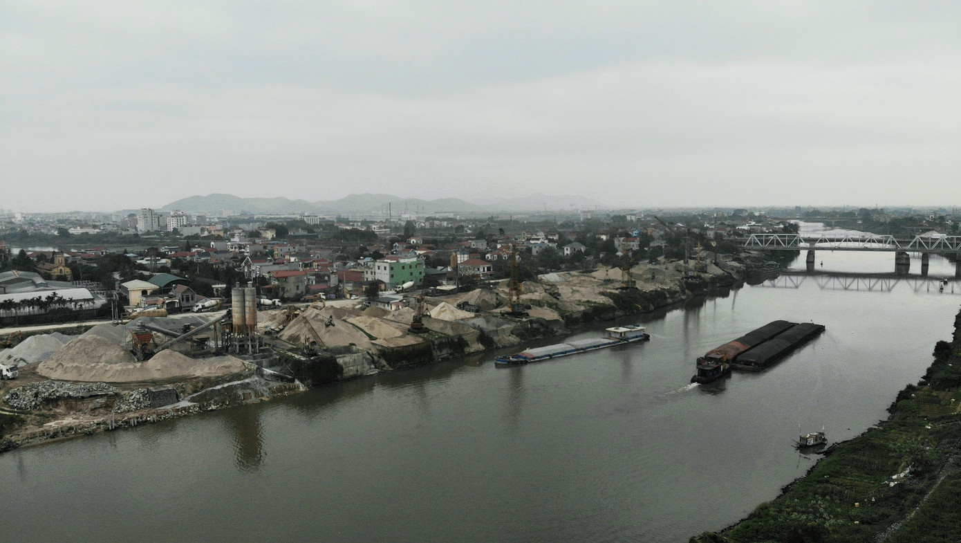 Từ trên cao qua thiết bị flycam có thể thấy hàng chục chiếc cẩu lớn ở mép sông hoạt động không ngừng nghỉ.