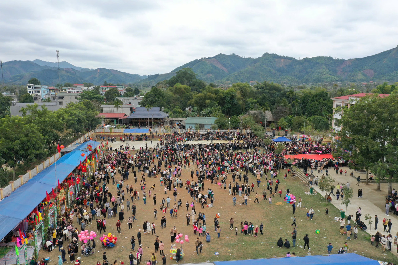 Trong không gian lễ hội, các gian hàng bày bán đủ loại sản vật địa phương như gạo, rau, bánh, rượu… tạo nên khung cảnh nhộn nhịp, đầy màu sắc.