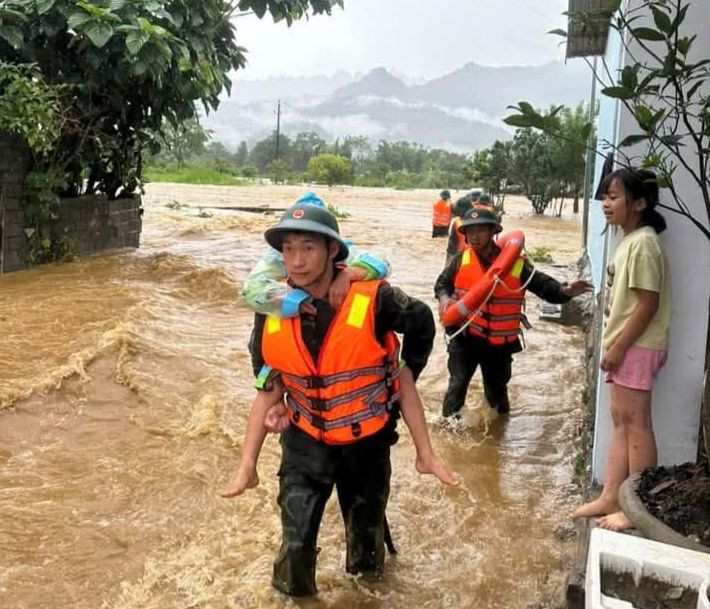 Người già, trẻ nhỏ được lực lượng cứu hộ, cứu nạn đưa đến nơi an toàn.