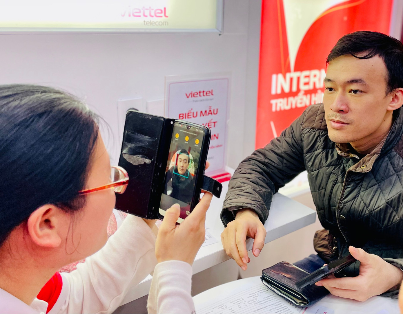 Nhân viên nhà mạng hỗ trợ khách hàng làm thủ tục chuyển thông tin từ chứng minh thư sang căn cước công dân.