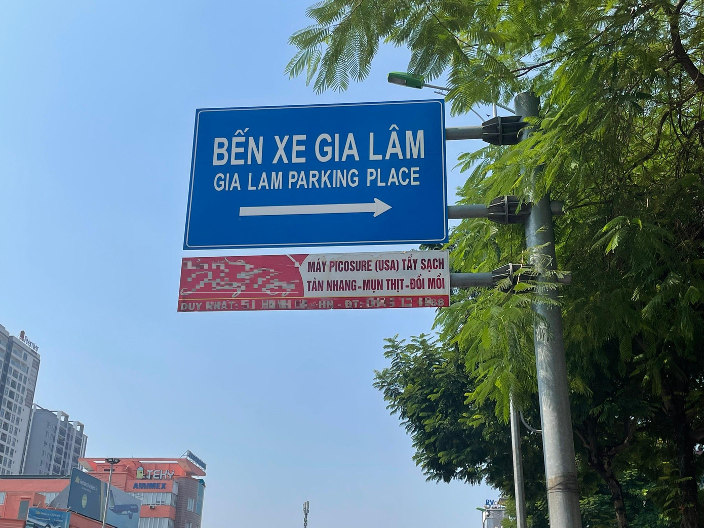 Biển quảng cáo gắn với biển chỉ dẫn giao thông trên đường Nguyễn Văn Cừ, Long Biên, Hà Nội