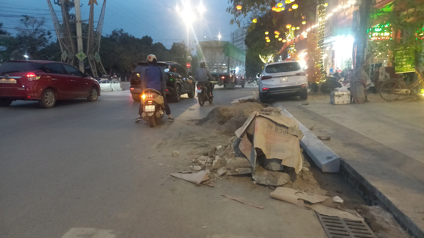 Theo người dân địa phương, đây là bãi đất đá được đổ ra trong quá trình thi công vỉa hè. Dù một số đoạn đã hoàn thiện cách đây gần một tuần, nhưng bãi đất vẫn chưa được dọn dẹp, tiềm ẩn nguy hiểm cho người tham gia giao thông.