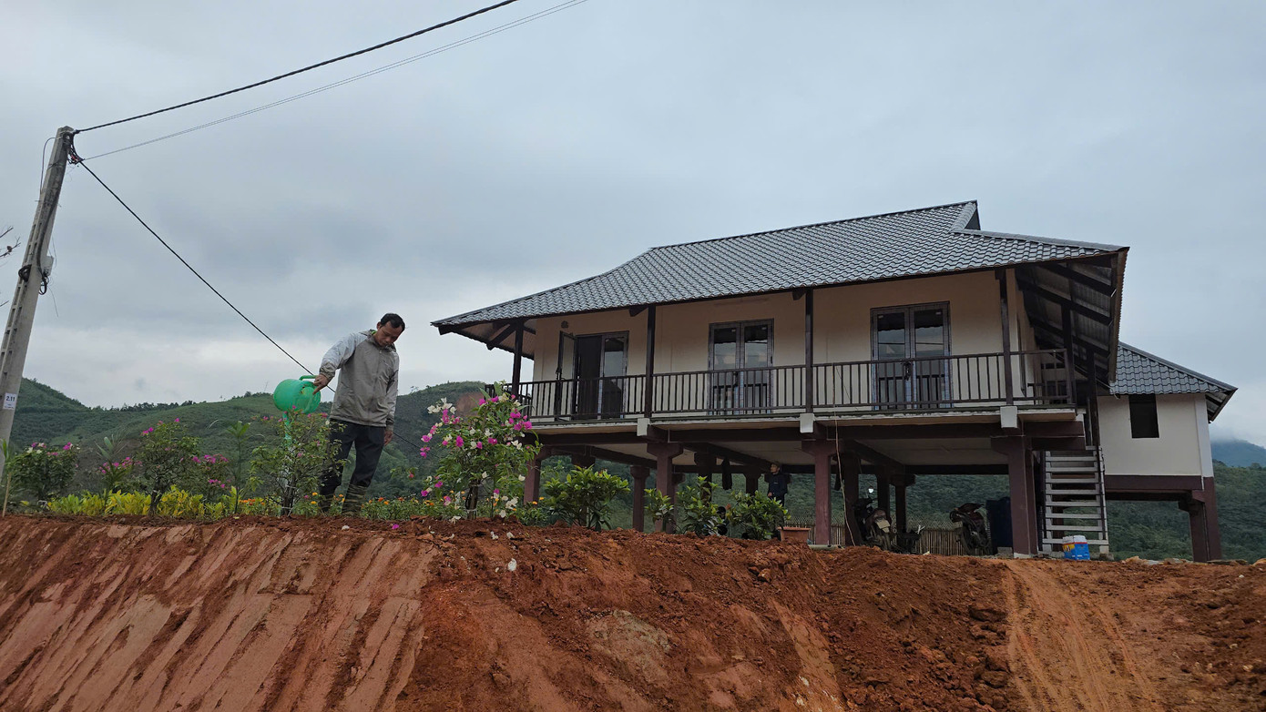 Anh Sầm Văn Bóng tranh thủ sau giờ làm, chăm sóc lại vườn hoa trước căn nhà mới. Trong trận lũ đầu tháng 9 vừa qua, anh Bóng mất đi 5 người thân cùng toàn bộ nhà cửa và tài sản. "Từ khi khu tái định cư bắt đầu xây dựng, cứ có thời gian rảnh là tôi lên đây hỗ trợ, vừa để khuây khỏa, vừa ngắm nhìn bản tương lai", anh Bóng chia sẻ.