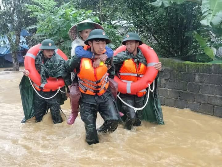 Người già, trẻ nhỏ được lực lượng cứu hộ, cứu nạn đưa đến nơi an toàn.