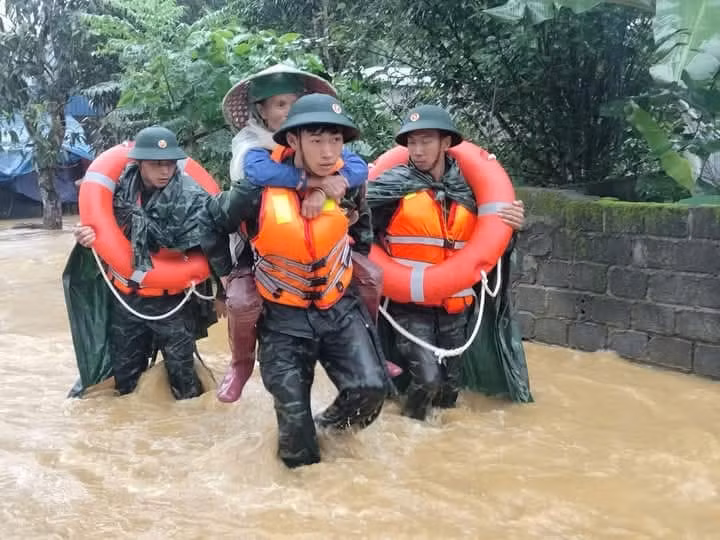Người già, trẻ nhỏ được lực lượng cứu hộ, cứu nạn đưa đến nơi an toàn.