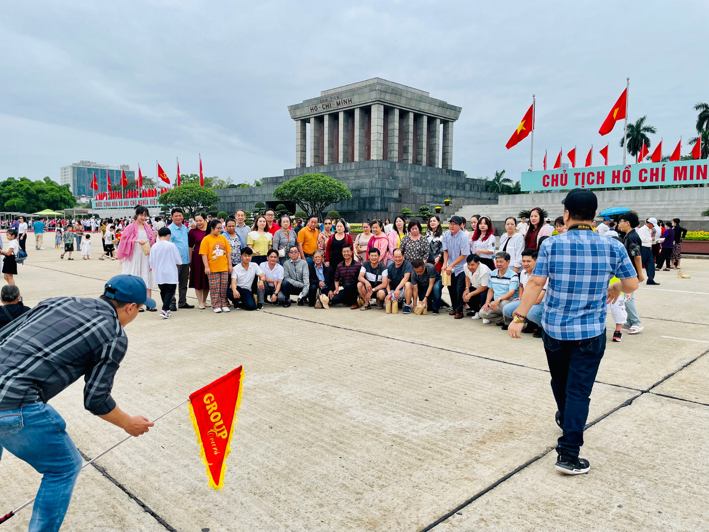 Một đoàn khách du lịch chụp ảnh kỷ niệm tại sân trước của Lăng