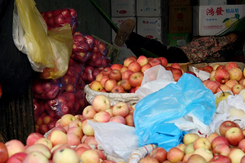 Một người bán hàng ngủ ngay bên sạp hoa quả vì ế ẩm.