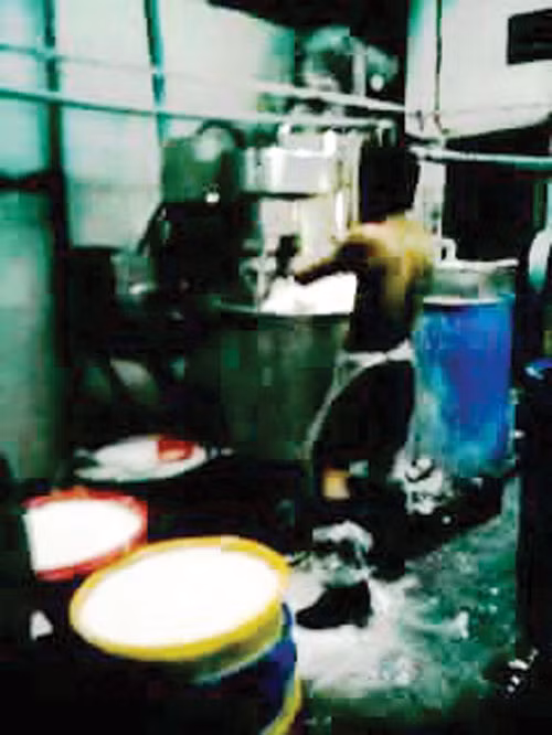 Nam công nhân đứng dẫm lên bột đổ trên sàn nhà. Ảnh: Hải Nguyên - Công Nguyên