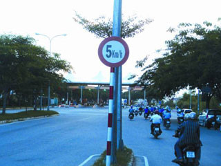 Một biển báo tốc độ 5km/h trước trạm thu phí trên đương Nguyễn Văn Linh