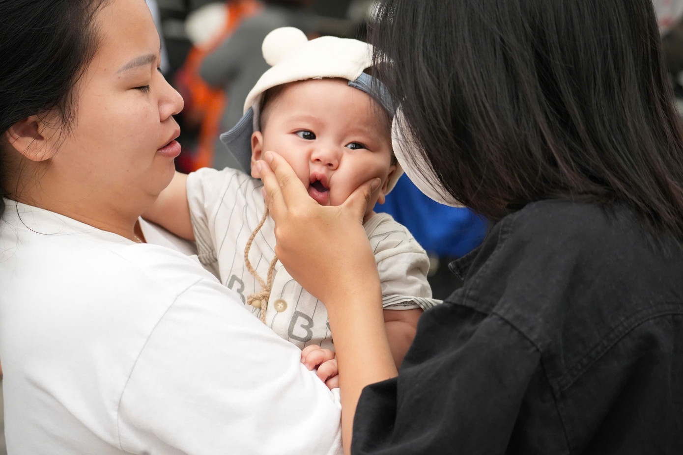 Một em bé được mẹ đưa đi cùng để tiễn chị gái đi thi