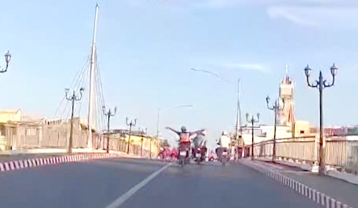 Người điều khiển xe máy buông 2 tay khi xe đang lưu thông trên đường được cho ở TP. Bạc Liêu (Ảnh cắt từ clip). Người điều khiển xe máy buông 2 tay khi xe đang lưu thông trên đường được cho ở TP. Bạc Liêu (Ảnh cắt từ clip).