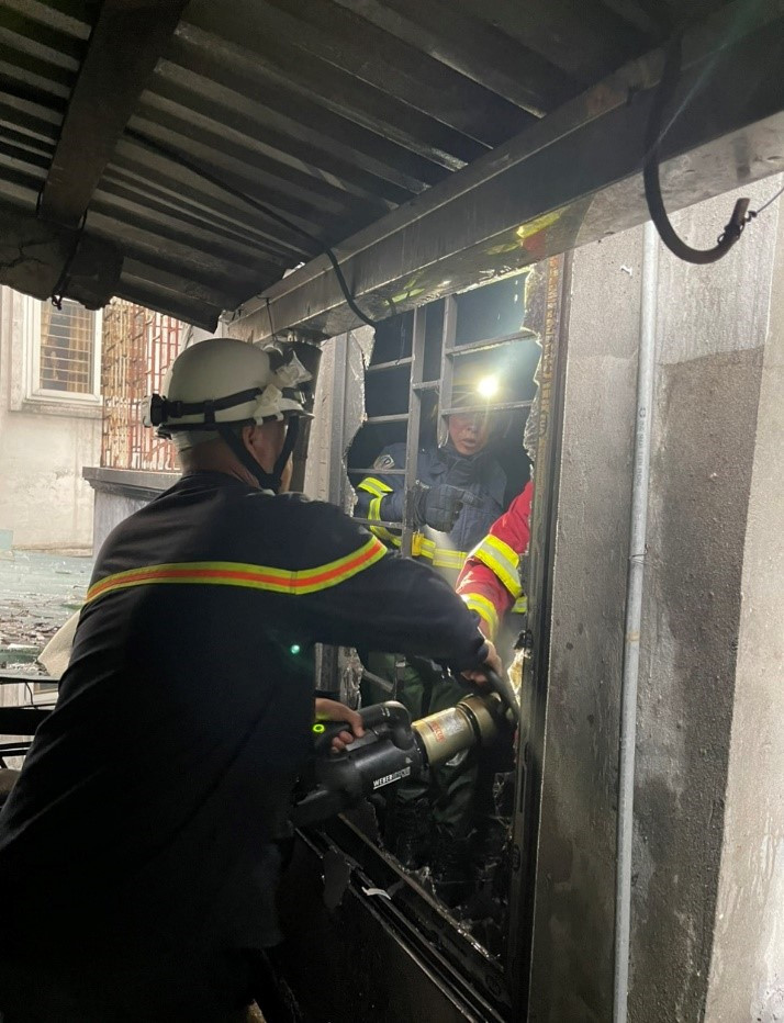 Lực lượng chữa cháy cắt phá khung cửa sắt.