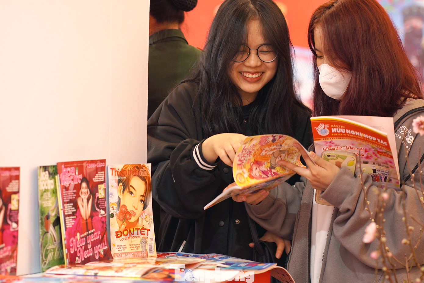 Bạn trẻ đọc các ấn phẩm tại gian trưng bày của báo Tiền Phong tại Hội báo Xuân Quý Mão - Hà Nội năm 2023. Ảnh: Xuân Tùng
