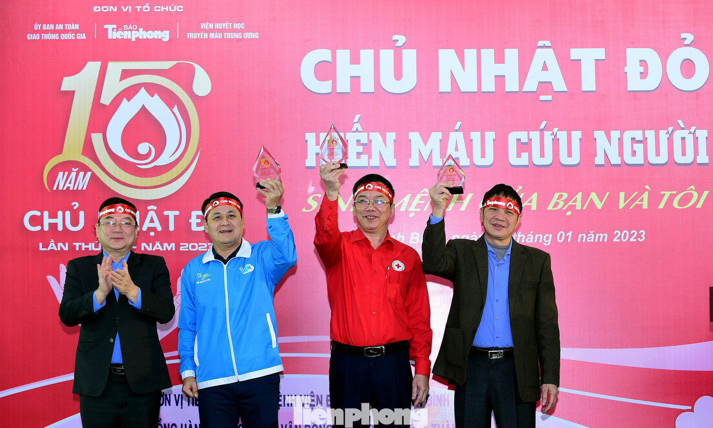 Nhà báo Lê Xuân Sơn tặng biểu trưng chương trình Chủ nhật Đỏ tới các đơn vị có nhiều đóng góp vào chương trình hiến máu. Ảnh: Xuân Tùng