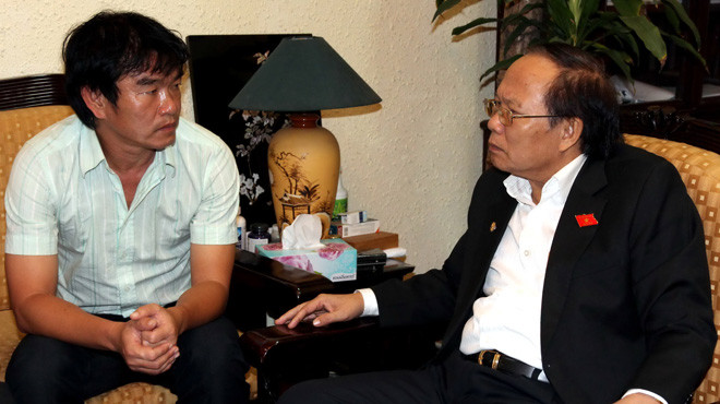 HLV Phan Thanh Hùng (trái) báo cáo Bộ trưởng Bộ VH-TT&DL Hoàng Tuấn Anh về tình hình đội tuyển trước giờ dự AFF Cup 2012 trưa 19-11