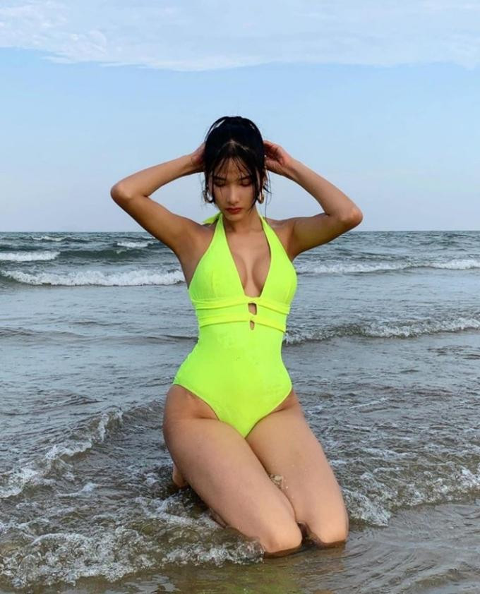 Á hậu Hoàng Thùy chọn áo tắm màu xanh lá với phần khoét cổ sâu khoe vòng một táo bạo.
