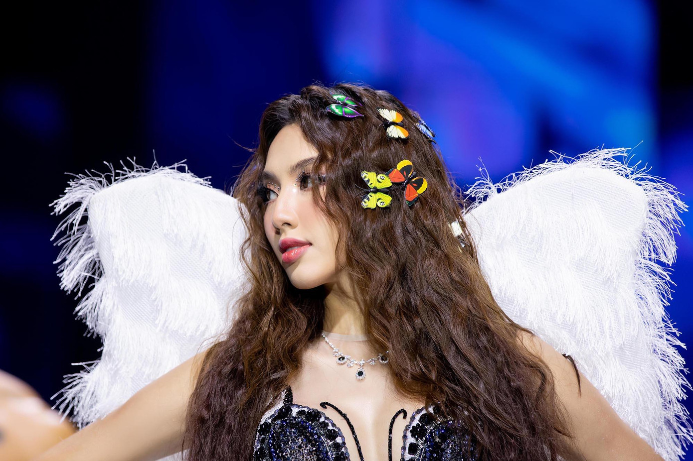 Diện thiết kế xuyên thấu màu tím với những bông hoa được đính kết cầu kỳ, đi kèm là đôi cánh bằng lông vũ trắng muốt, Hoa hậu Thuỳ Tiên sải những bước đi đầy thần thái và chuyên nghiệp trên sàn catwalk.