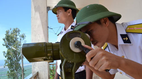 Thiếu úy Vương Huy Thọ (trái) và thiếu úy Nguyễn Văn Hợi quan sát vùng biển Phú Yên từ trạm rađa 560 trên đỉnh núi Chóp Chài. Ảnh: Duy Thanh