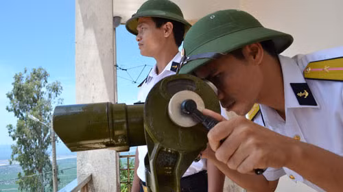 Thiếu úy Vương Huy Thọ (trái) và thiếu úy Nguyễn Văn Hợi quan sát vùng biển Phú Yên từ trạm rađa 560 trên đỉnh núi Chóp Chài. Ảnh: Duy Thanh