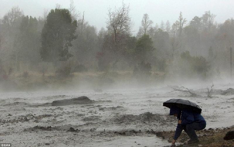 Một người đàn ông nhúng tay vào bùn để thử nhiệt độ. Một người đàn ông nhúng tay vào bùn để thử nhiệt độ