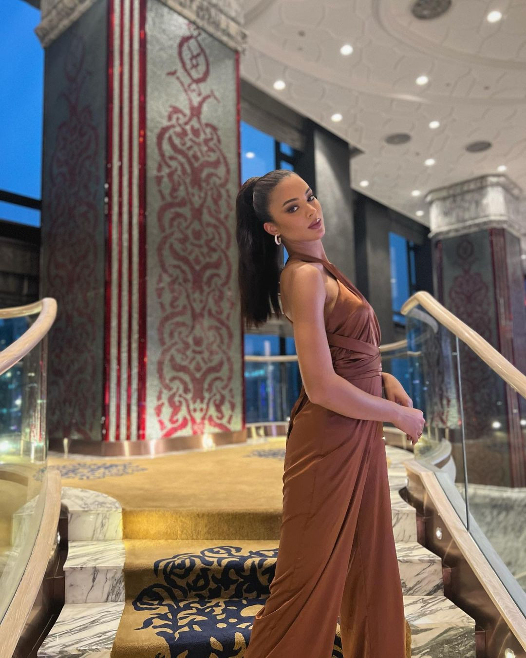 Á hậu 2 Hoa hậu Hoàn vũ 2022 - Andreína Martínez diện bộ jumpsuit cut-out tông màu nâu sang trọng khi tới Việt Nam. Cô cũng tạo dáng chụp ảnh khi về tới khách sạn ở TPHCM.