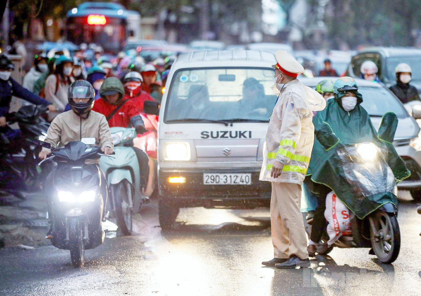 Hình ảnh cán bộ, chiến sĩ CSGT đứng dưới mưa phân luồng tránh ùn tắc tại tuyến đường Hồ Tùng Mậu (Cầu Giấy, Hà Nội).