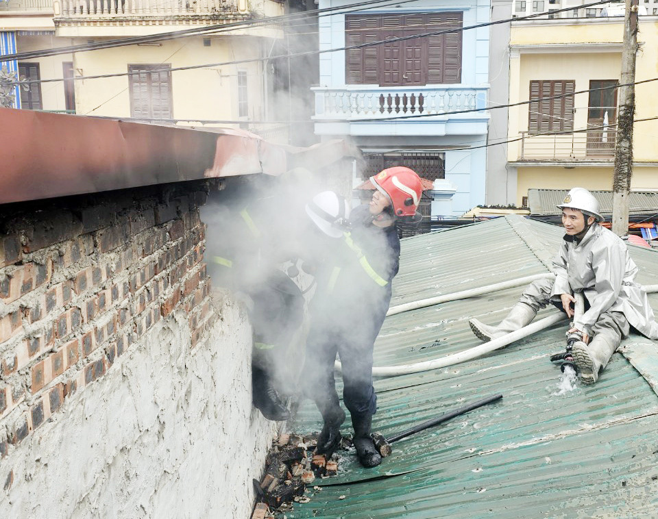 Lực lượng PCCC phá tường dập lửa bên trong.