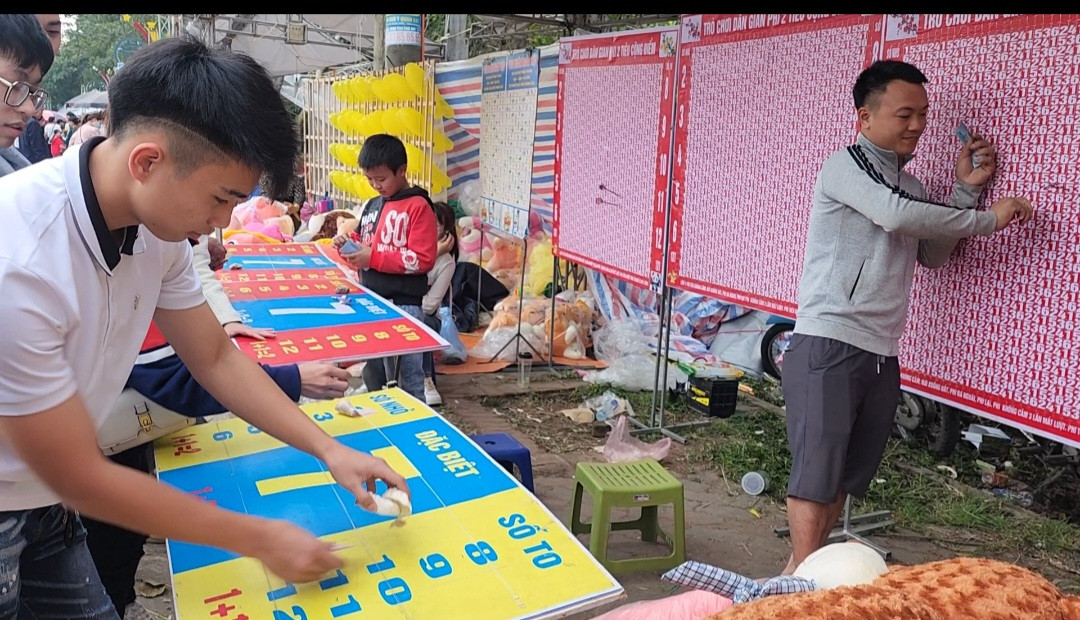 Du khách đặt tiền chơi trò ném phi tiêu cộng điểm trúng thưởng tại Khu du lịch- di tích Đền Sóc