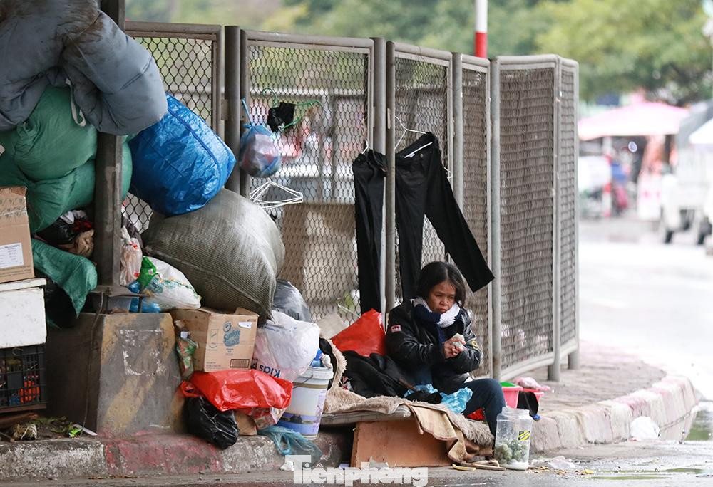 Một người vô gia cư ngồi ven dưới chân cầu Ngã Tư Sở