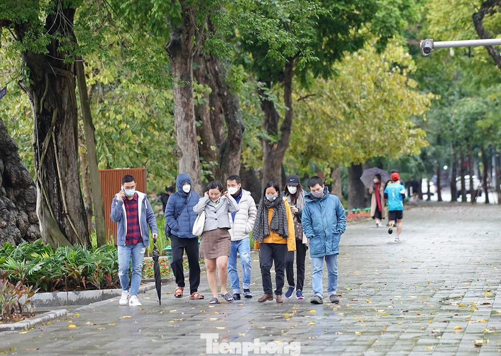 Đa số người dân đều mặc áo ấm, trùm kín mít để tránh gió lạnh.