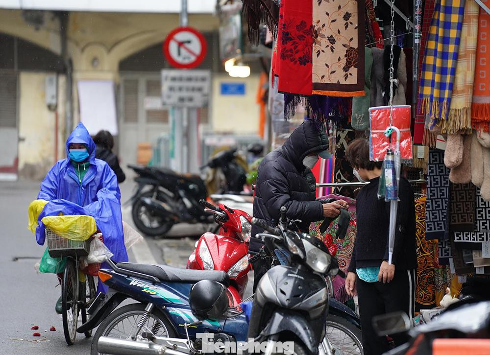 Một người dân dừng xe trên phố Đinh Liệt (quận Hoàn Kiếm) để mua găng tay len do thời tiết quá buốt giá