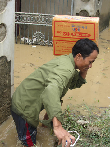 Một người dân với thùng mì tôm cứu trợ. Ảnh: Q.L