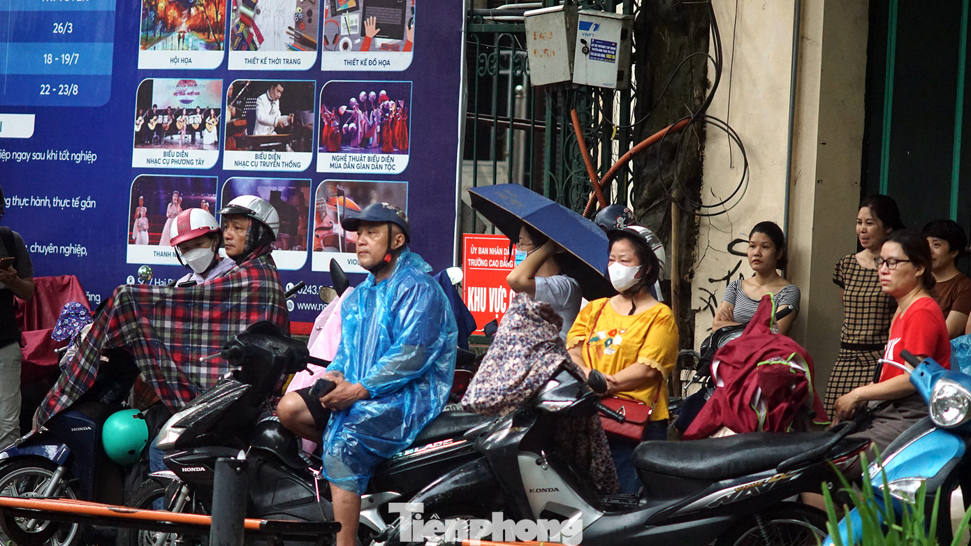 Nhiều phụ huynh đội mưa chờ con ngoài điểm thi.