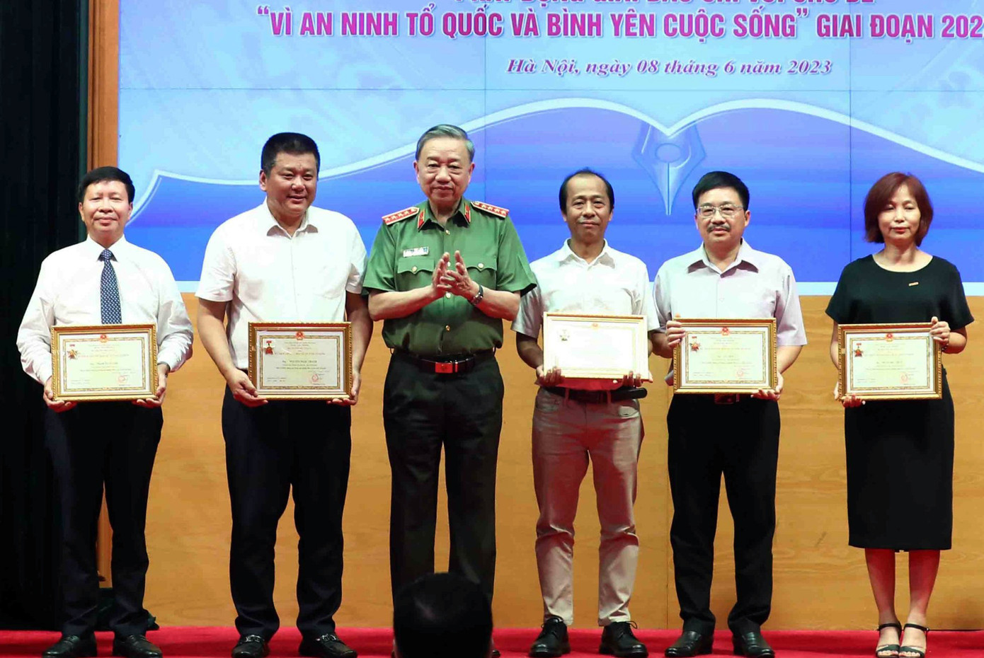 Nhà báo Vũ Tiến - Phó tổng Biên tập Báo Tiền Phong (thứ 2 từ phải qua) nhận Kỷ niệm chương “Bảo vệ an ninh Tổ quốc”. Ảnh: Phạm Kiên