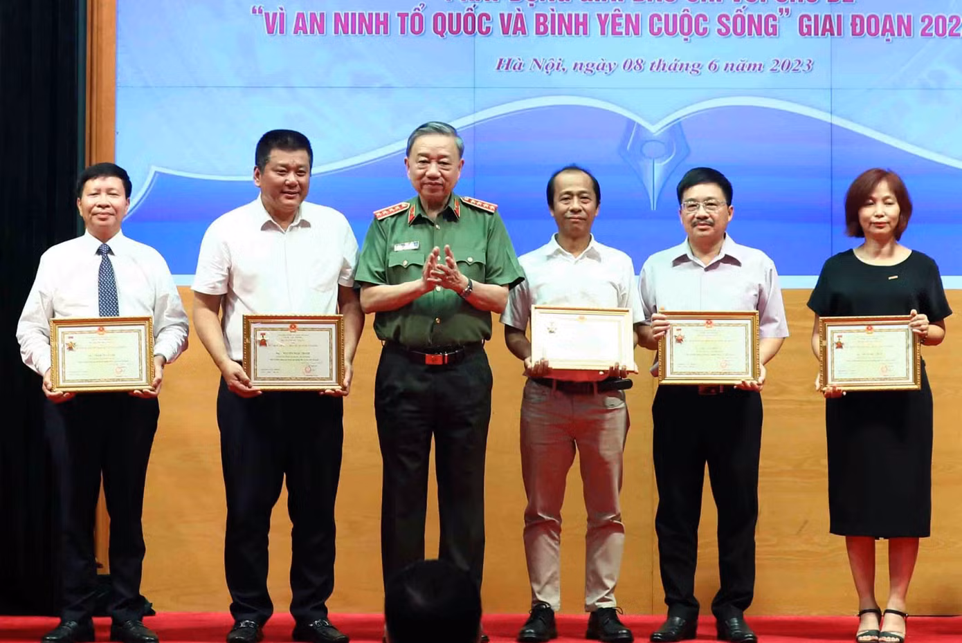 Nhà báo Vũ Tiến - Phó tổng Biên tập Báo Tiền Phong (thứ 2 từ phải qua) nhận Kỷ niệm chương “Bảo vệ an ninh Tổ quốc”. Ảnh: Phạm Kiên
