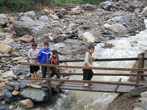 Một cây cầu tạm được đoàn viên thanh niên địa phương và bà con nhân dân dựng lên cho học sinh đi dự lễ khai giảng năm học mới