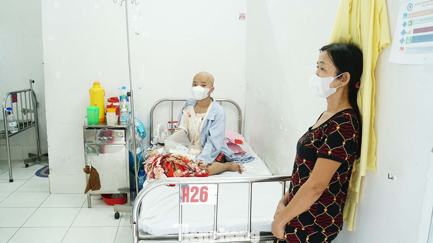 Bà Nguyễn Thị Tr. đứng bên cạnh con gái - Trương Thị Tr.L., sinh viên năm 3, Trường Đại học Cần Thơ (quê ở An Giang). Tr.L. bị ung thư máu đang điều trị tại bệnh viện. “Gia đình tôi nghèo, có 2 đứa con. Chồng đi làm thuê, con trai lớn nghỉ học ở nhà phụ hồ. Con gái đang học đại học bỗng phát hiện ung thư máu cách nay hơn 2 tháng rồi vô đây điều trị. Hằng ngày, gia đình làm thuê để gửi tiền xuống lo con chữa trị”, bà Tr. nói. Ảnh: Hòa Hội.