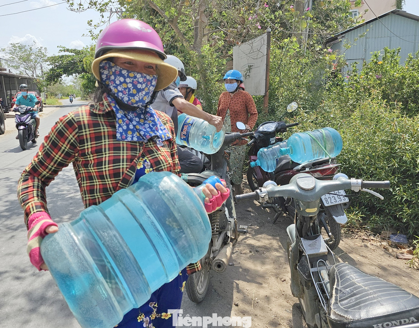 Người dân bê bình nước ngọt về nhà. Ảnh: Hòa Hội