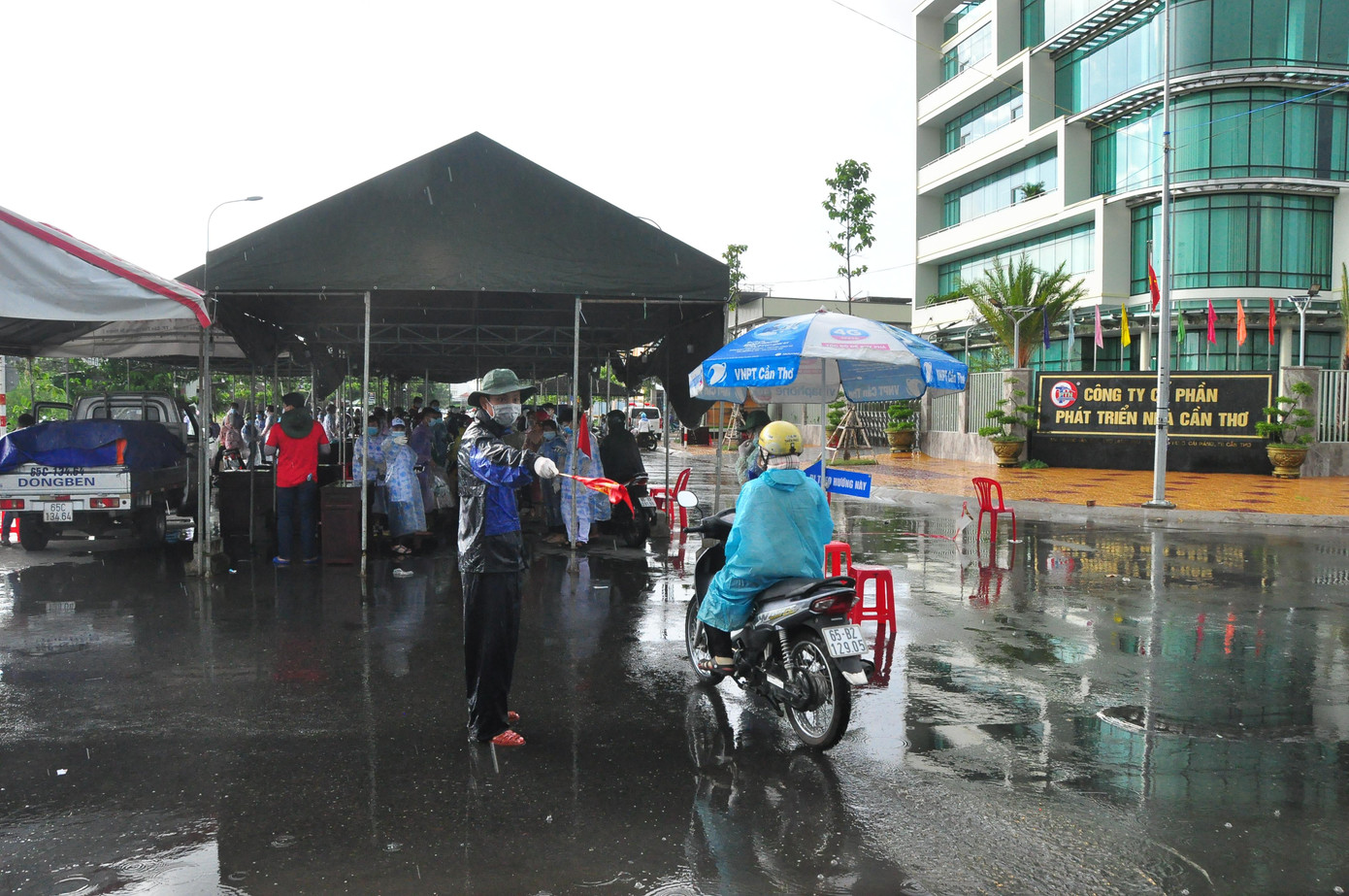 Tình nguyện viên dầm mưa hướng dẫn người dân khai báo y tế