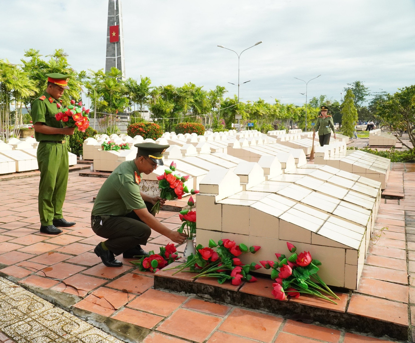 Chiến sĩ công an thay hoa tại các phần mộ liệt sĩ.
