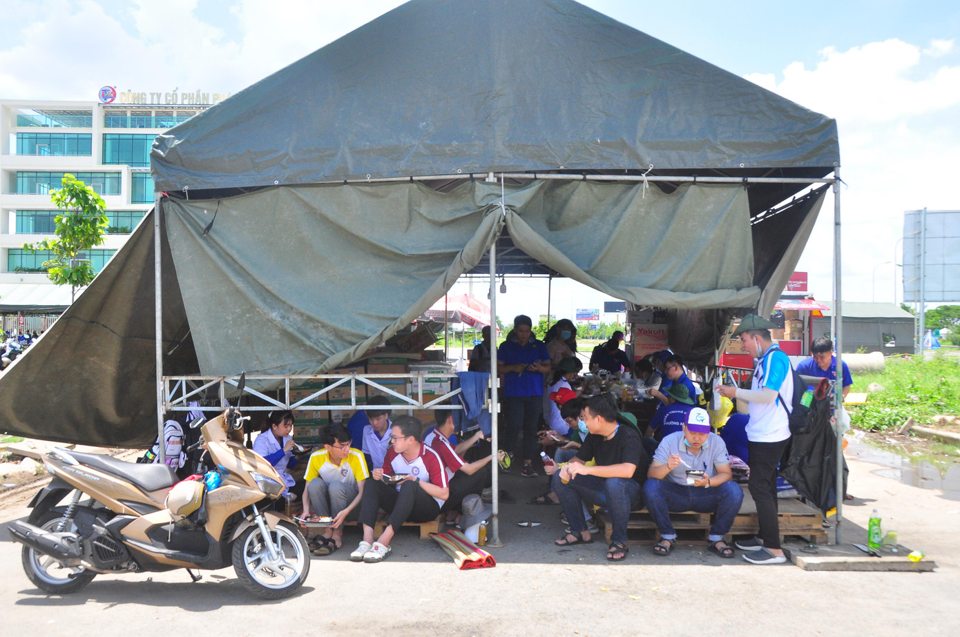 Các bạn tình nguyện viên ăn cơm trưa từ mạnh thường quân hỗ trợ. - Ảnh: Hòa Hội