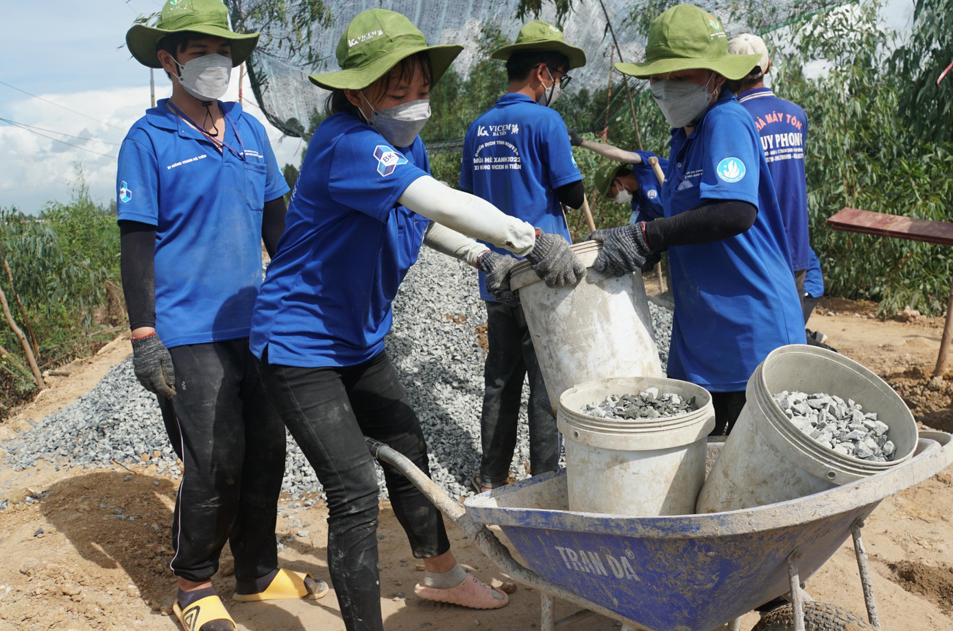 Mỗi người mỗi việc, từ khuân cát, đá, xi măng, đứng cối, các bạn phối hợp với nhau một cách nhịp nhàng. Tiếng nói cười vui vẻ, nhộn nhịp giữa nắng gắt và cánh đồng không bóng người đã xua đi bao mệt mỏi, vất vả. - Ảnh: Hòa Hội